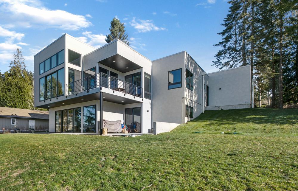 A two-story home with a minimalist look, light gray siding and clean lines.