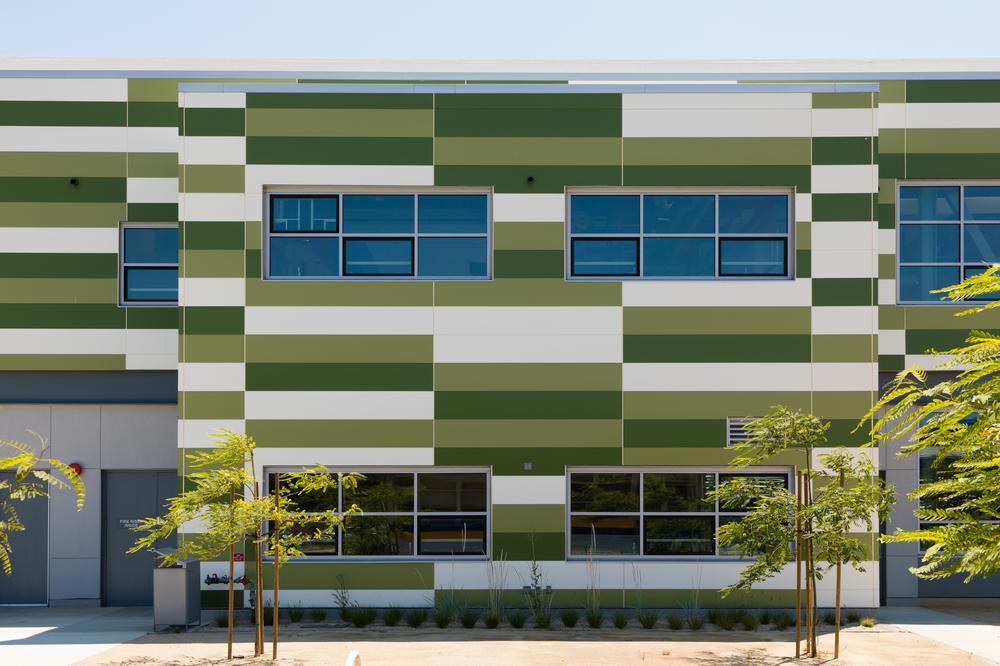 Mount Eden High School with Nichiha&rsquo;s custom colored fiber cement commercial cladding in different shades of green and white.