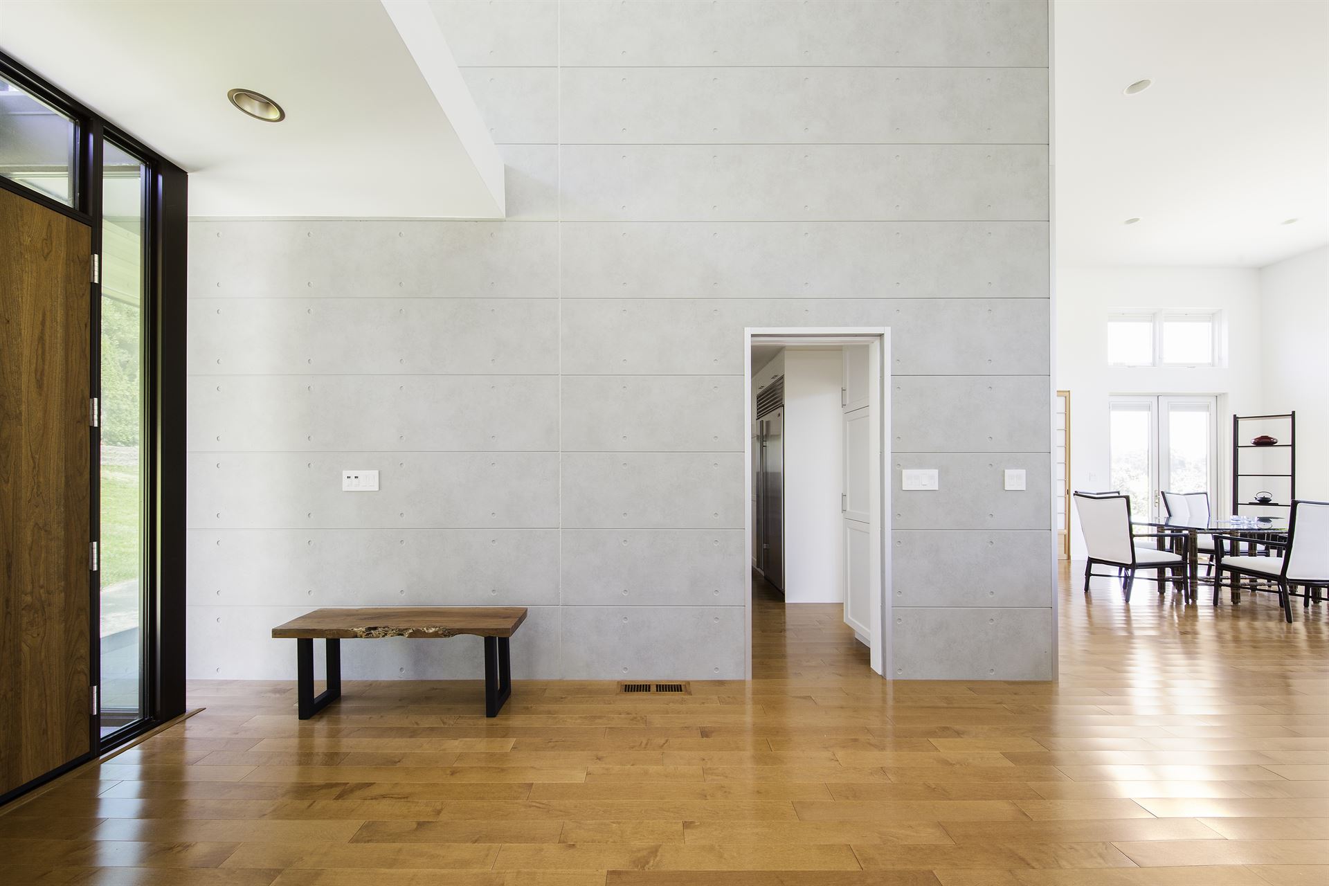 The entryway of a home with hardwood floors and a gray accent wall utilizing Nichiha Empire Block.