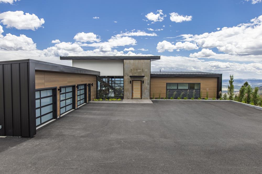 An industrial-style home with Nichiha’s fiber cement siding with blue skies and clouds in the background.