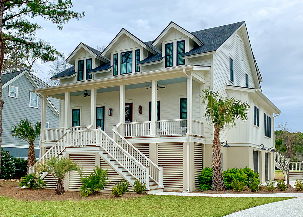Traditional cream house with lap siding and palm trees