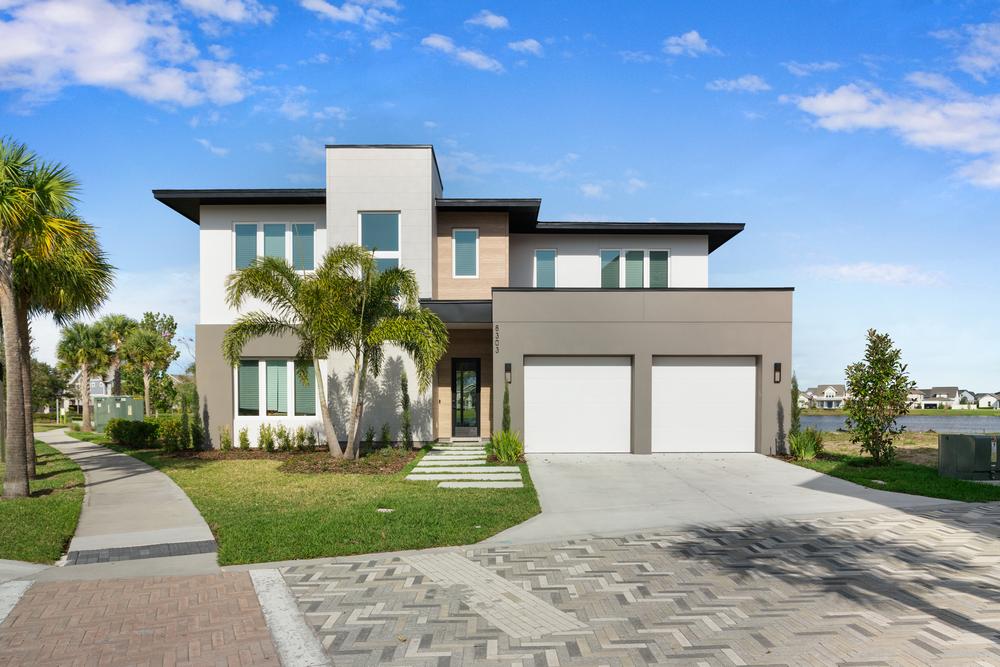 Sand-colored stucco-style fiber cement siding on a home above the brick half wall.