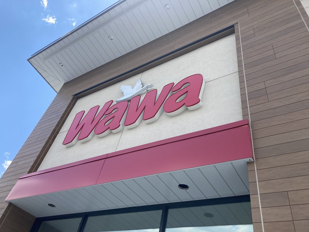 A close-up shot of the logo of Wawa in red utilizing Nichiha’s fiber cement cladding in brown and light tan.