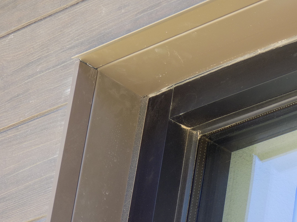 The corner of a window with black Nichiha J-Mold and J-Trim surrounded by Vintage Wood fiber cement panels.