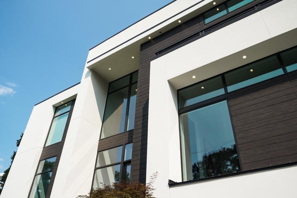 A home in Atlanta Georgia that’s white and dark brown with large windows utilizing Nichiha’s VintageWood. This image looks up at the home’s siding.