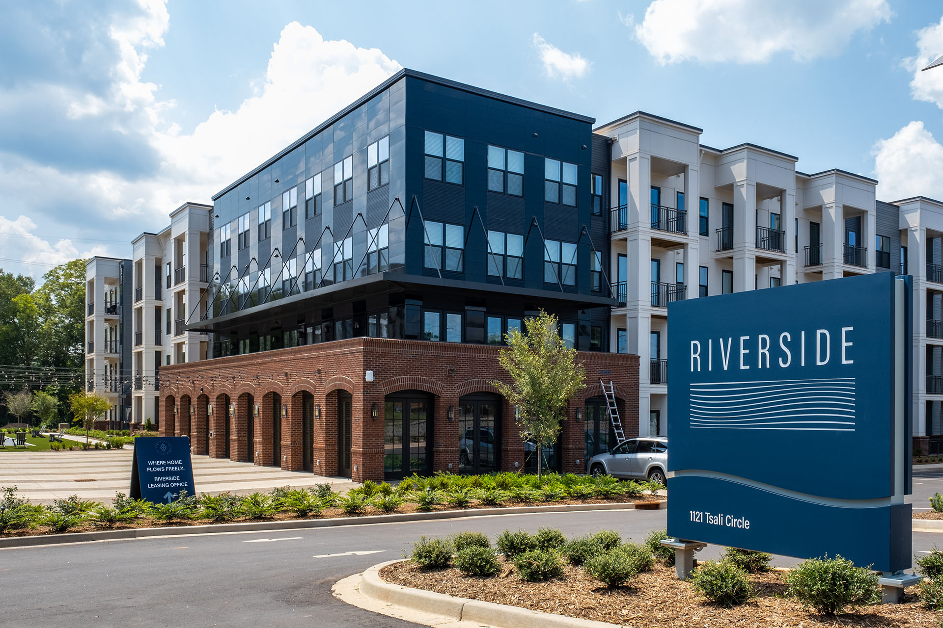 Riverside multi-family housing development with Nichiha’s Miraia panels in Onyx on top of brick pedestals