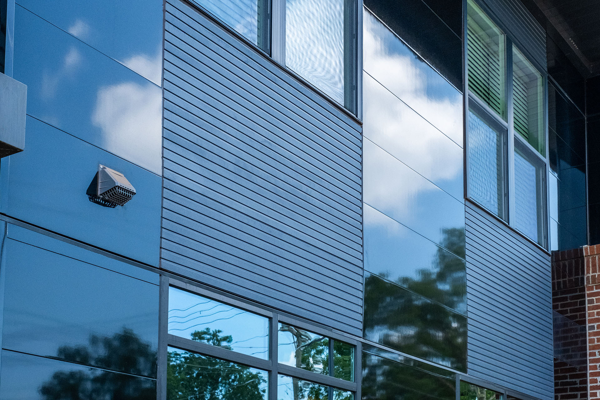 close up of ribbed indigo fiber cement panels next to miraia panels in onyx