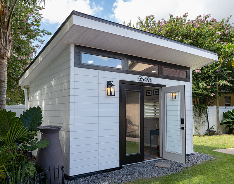 Front view of modern home DIY studio with door open and sconce lights on