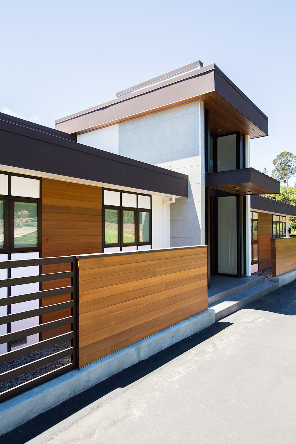 Side angle of a modern home with Nichiha's concrete series paired with wood cladding