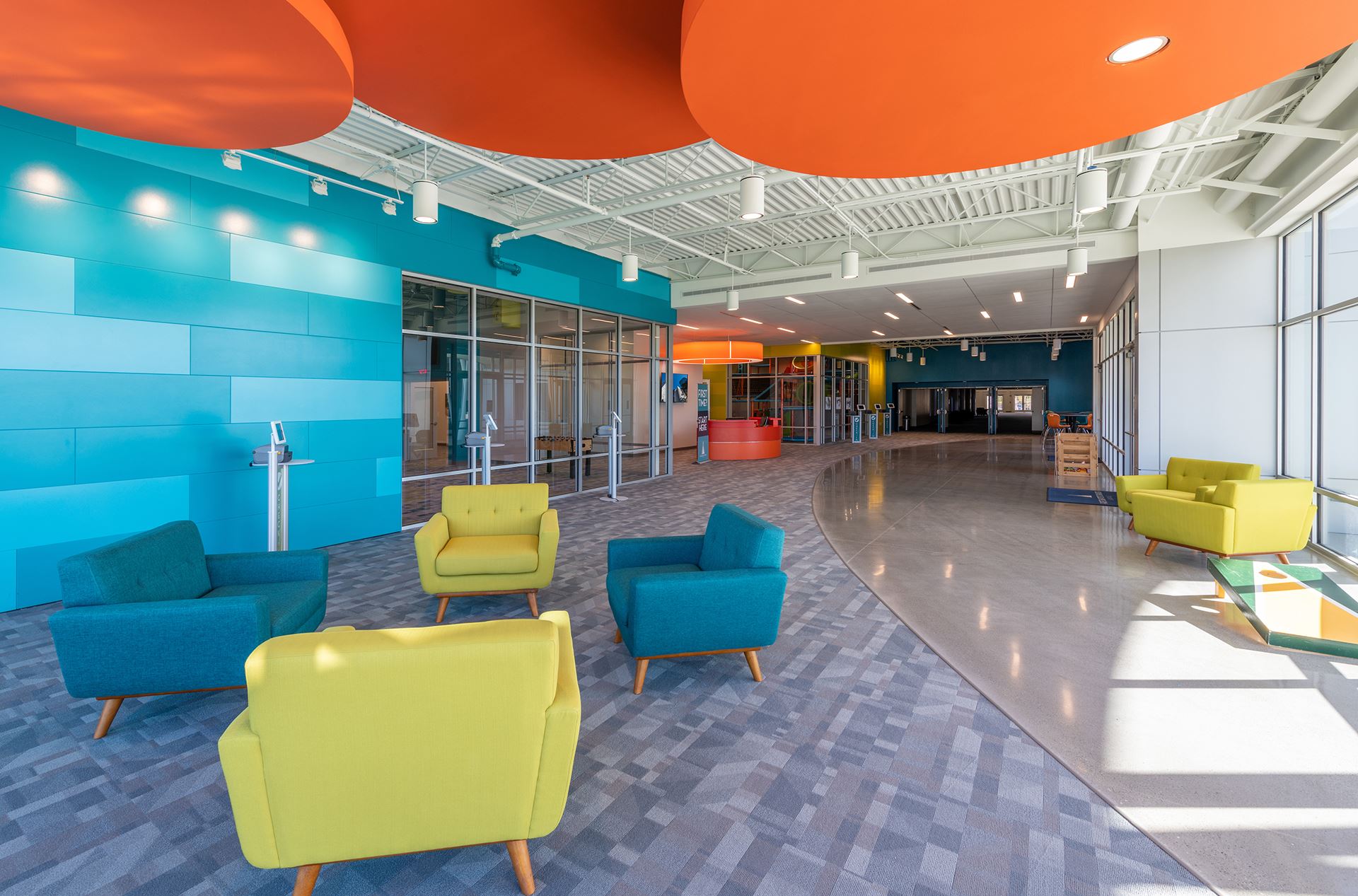 Inside lounge area with colorful blue Illumination panels and green accent chairs