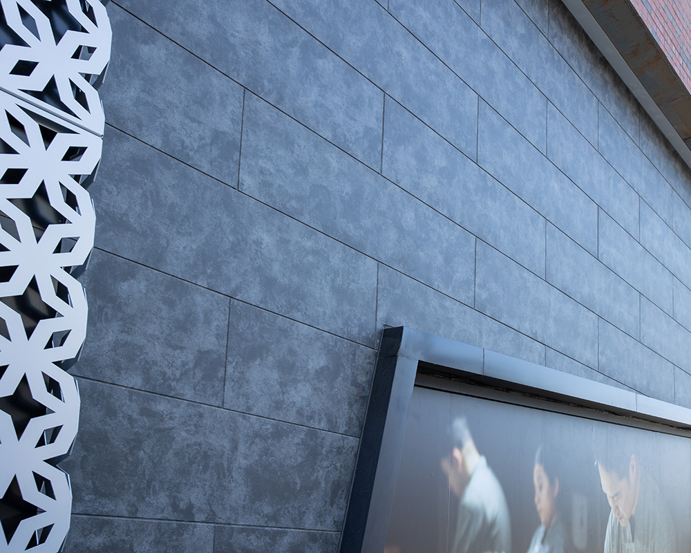 Close up photo of the new Corbosa fiber cement panel in Shadow installed on a retail building
